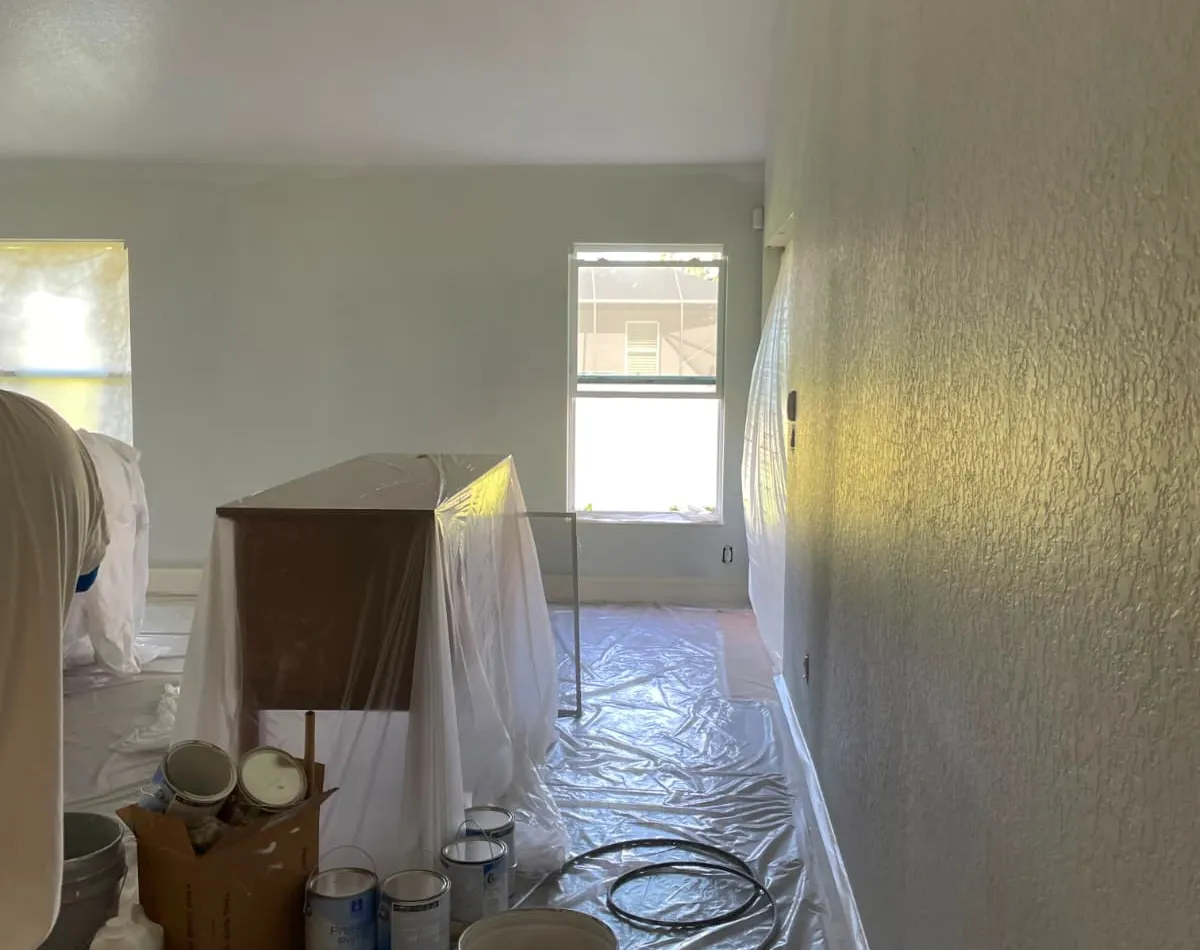 Interior painting in progress with spray application