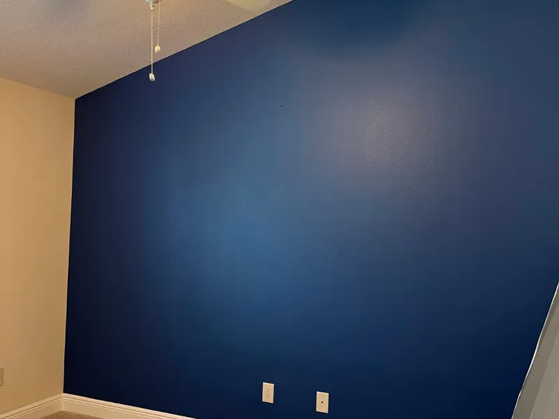 Navy blue accent wall in a freshly painted bedroom