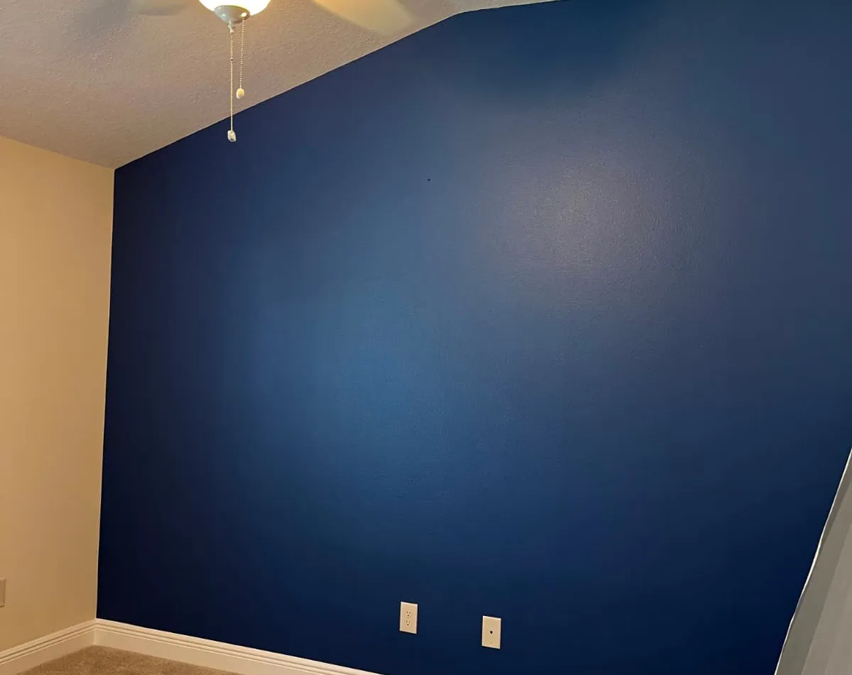 Navy blue accent wall in a freshly painted bedroom
