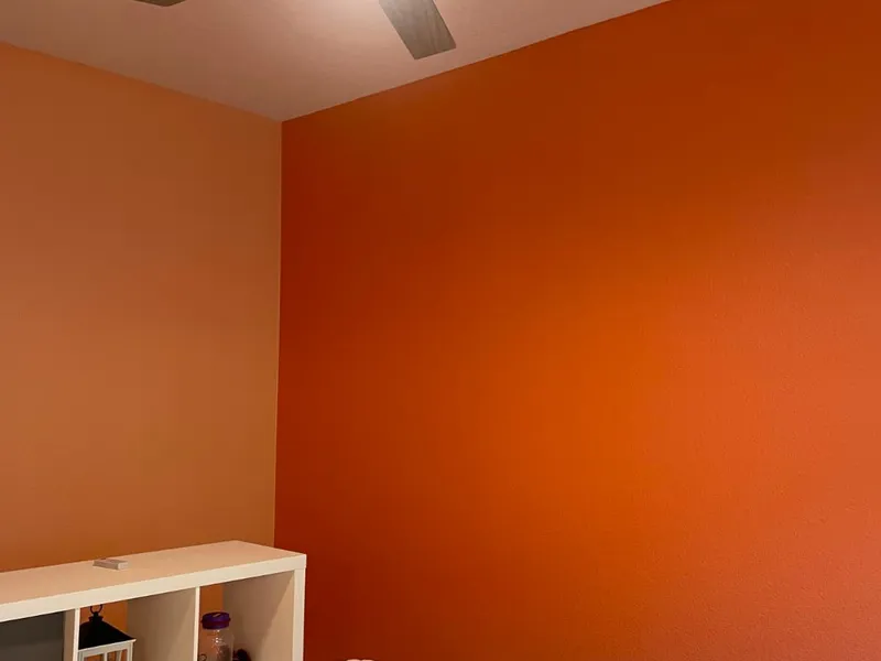 Orange accent wall in a freshly painted bedroom