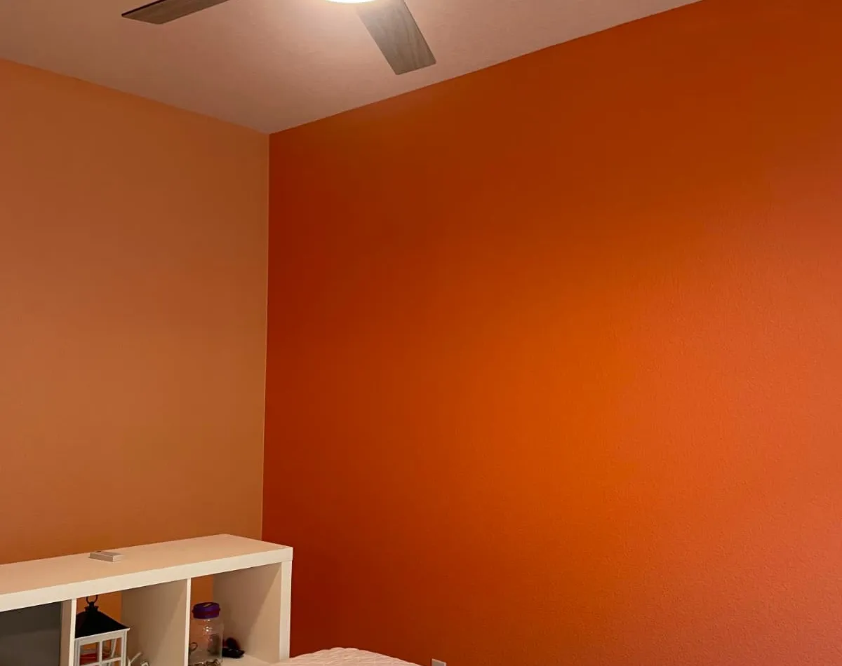 Orange accent wall in a freshly painted bedroom